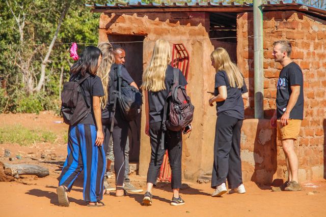 A group of volunteers beside brick pit latrines