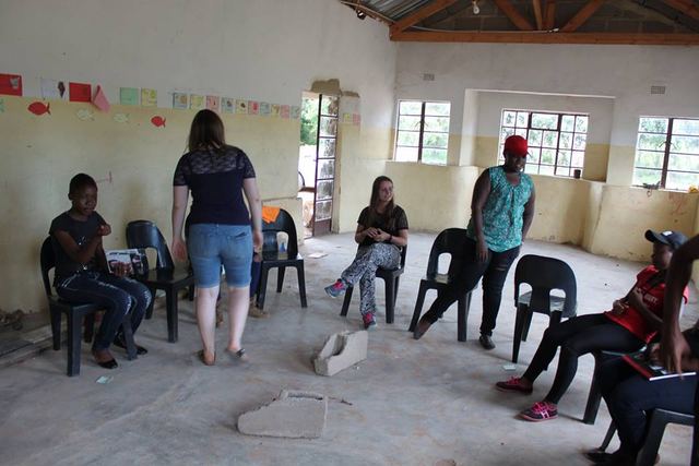 A group session in a hall, with participants seated in a circle