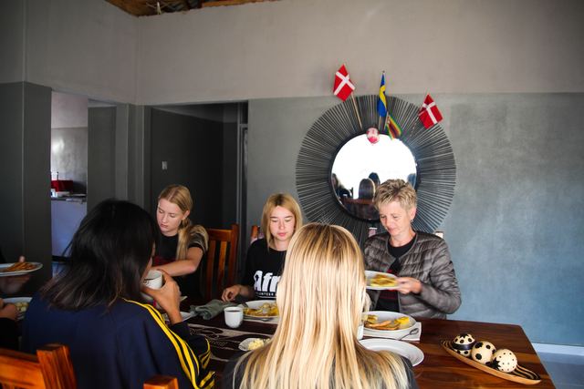 Volunteers eating at a table beneath a mirror decorated with small flags